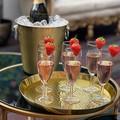 Flutes of champagne and strawberries on a golden tray, bottle of champagne in an ice cooler, at Debden House