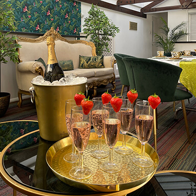 Flutes of champagne and strawberries on a golden tray, bottle of champagne in an ice cooler, at Debden House